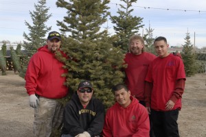 Big M Services team standing in front of Christmas Tree