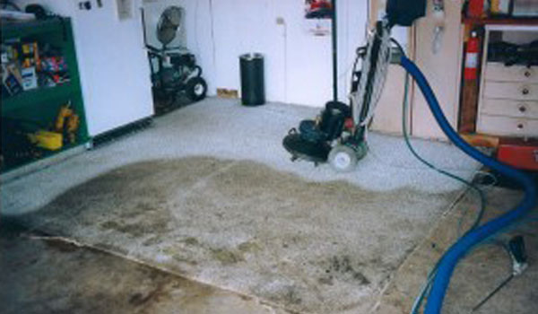 Commercial rug cleaning vacuum on dirty, white rug