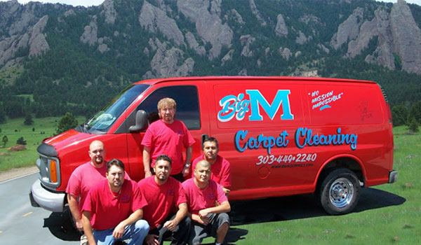 Big M Services team standing in front of red work truck